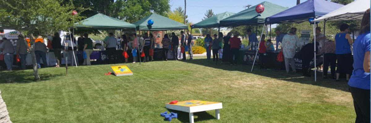 employee event with vendor tents and cornhole game